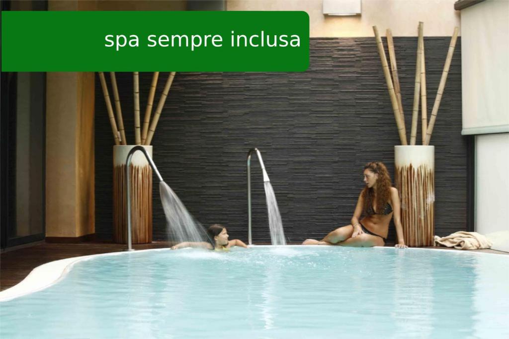 Due donne sedute in una vasca idromassaggio in un hotel di Residence Eden & Spa a Gabicce Mare