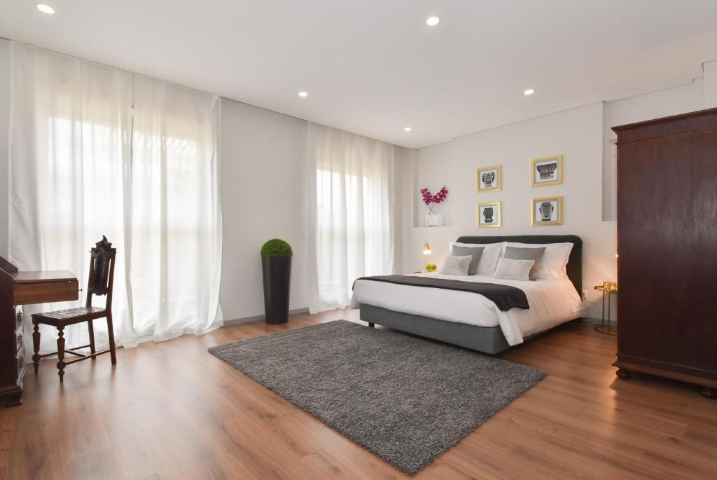 a bedroom with a large bed and a piano at Rosario's Boutique Apartments in Porto