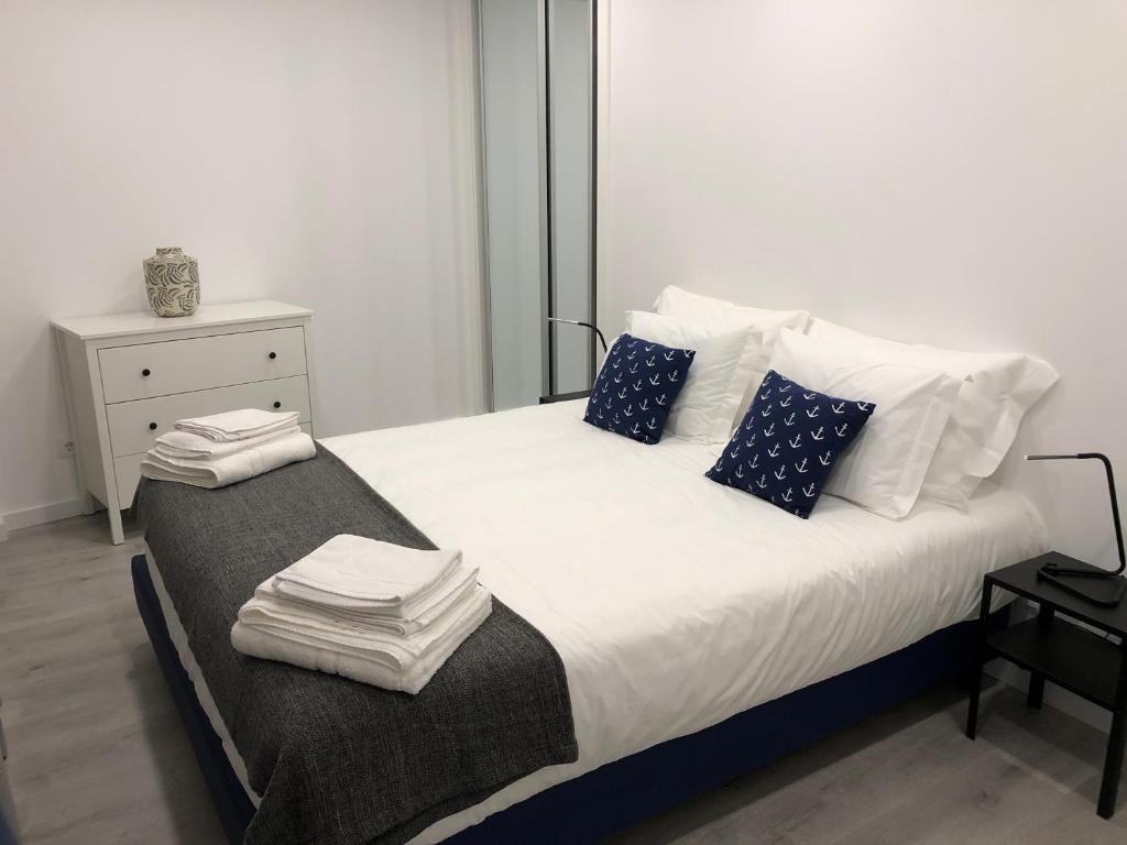 カルダス・ダ・ライーニャにある120 Central Apartmentのベッドルーム1室(大型ベッド1台、青と白の枕付)
