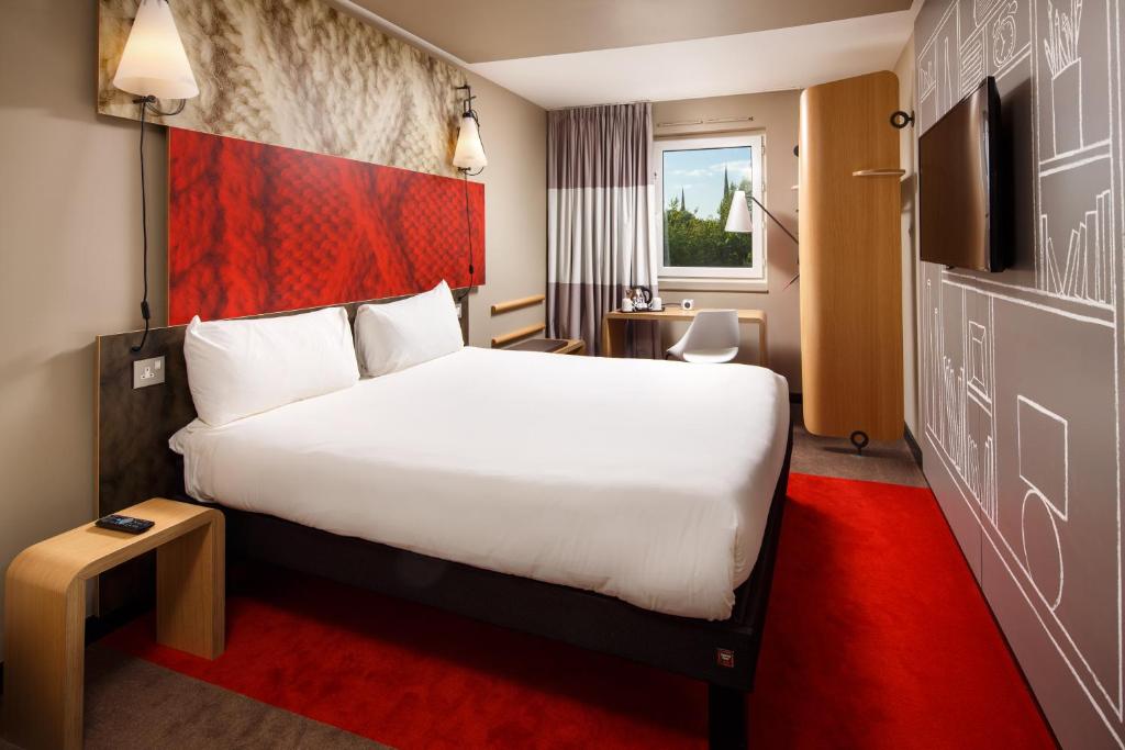 
a hotel room with a bed and a dresser at ibis Coventry Centre in Coventry
