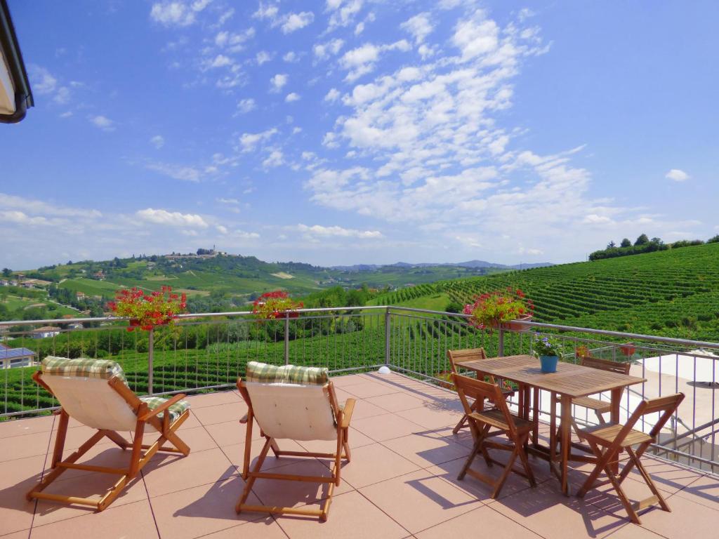 patio con mesa, sillas y vistas en Agriturismo Cà del Nono en San Marzano Oliveto