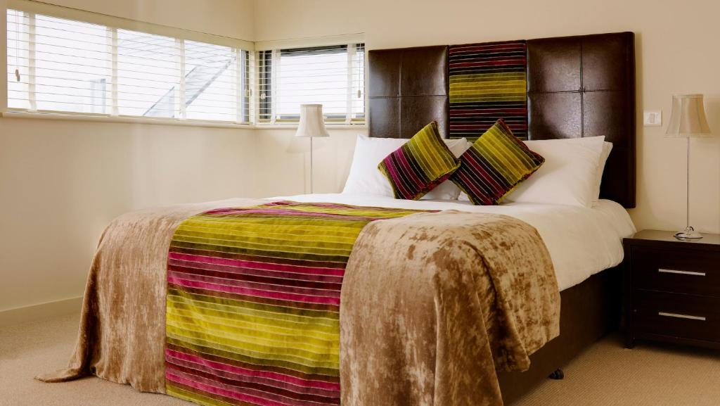 a bedroom with a large bed with a colorful blanket at Great Southern Killarney Holiday Homes in Killarney