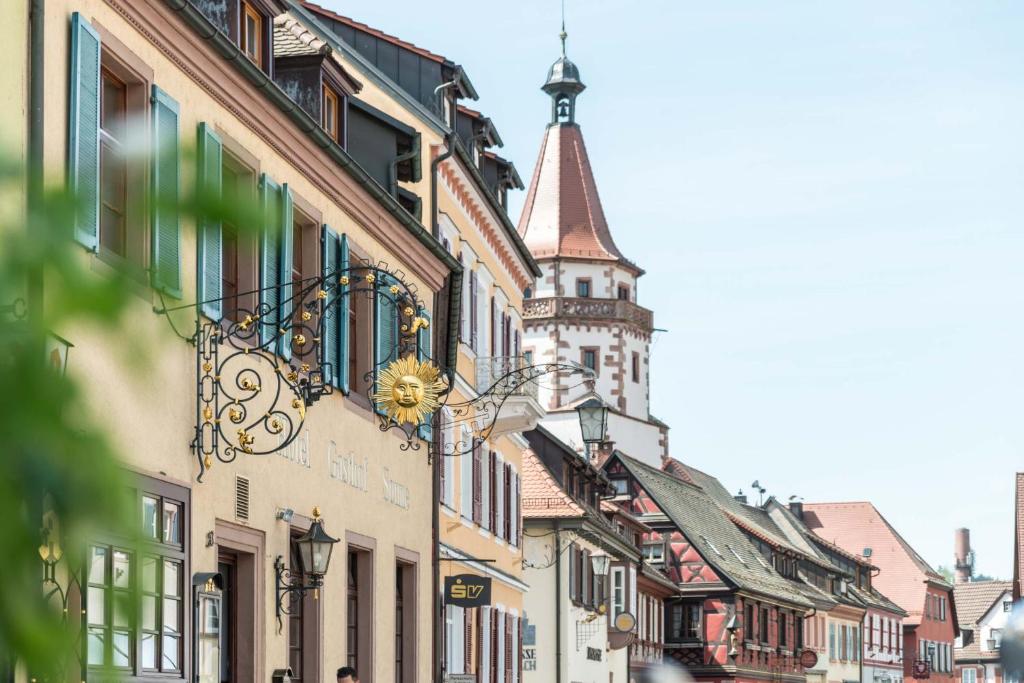 a city street with a clock tower in the background at Hotel Restaurant Sonne in Gengenbach