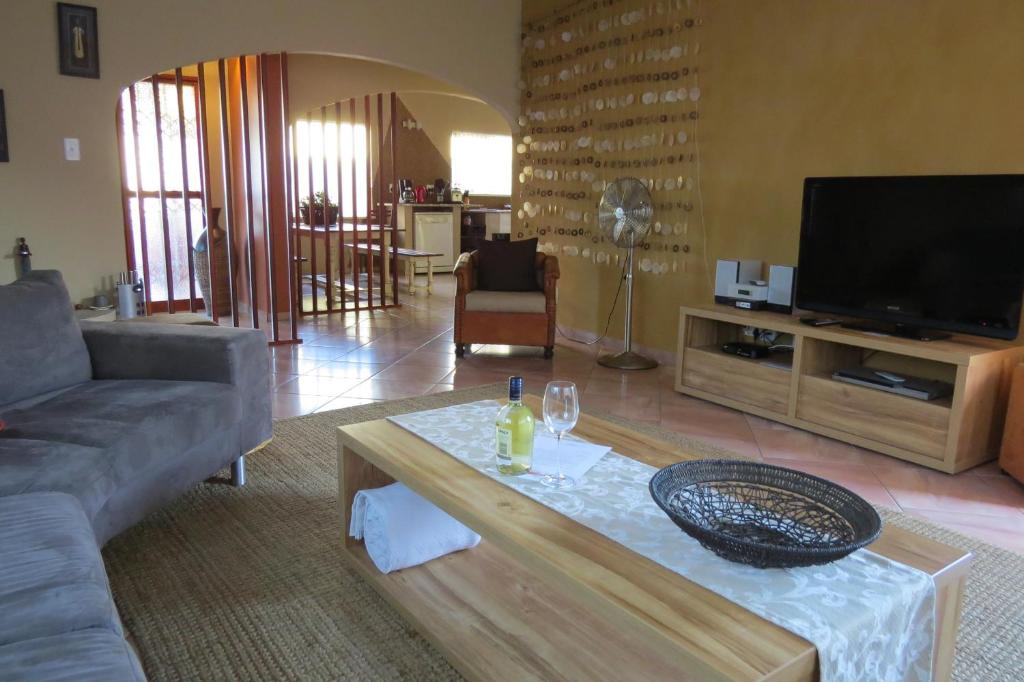 a living room with a couch and a tv at Beach Walk House and Cottage - Self Catering in Swakopmund