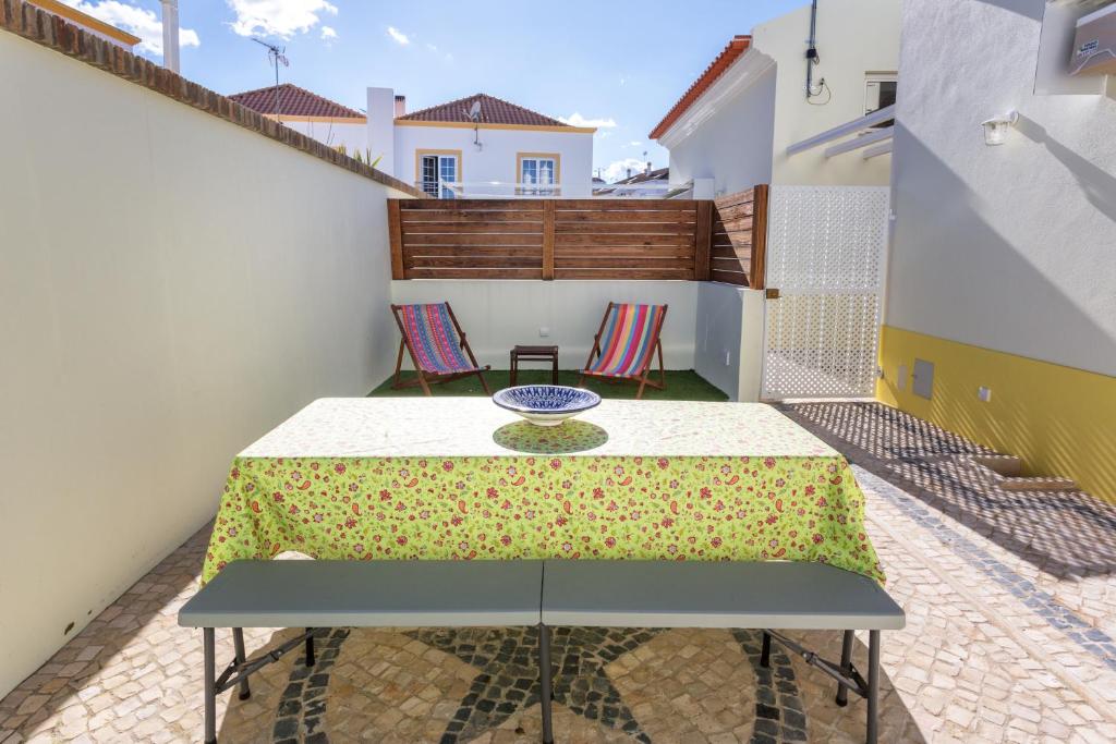 a patio with a table and chairs on a balcony at As Serenas Casa B in Vila Nova De Cacela