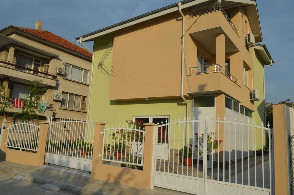 a yellow house with a white fence in front of it at Yanis in Chernomorets