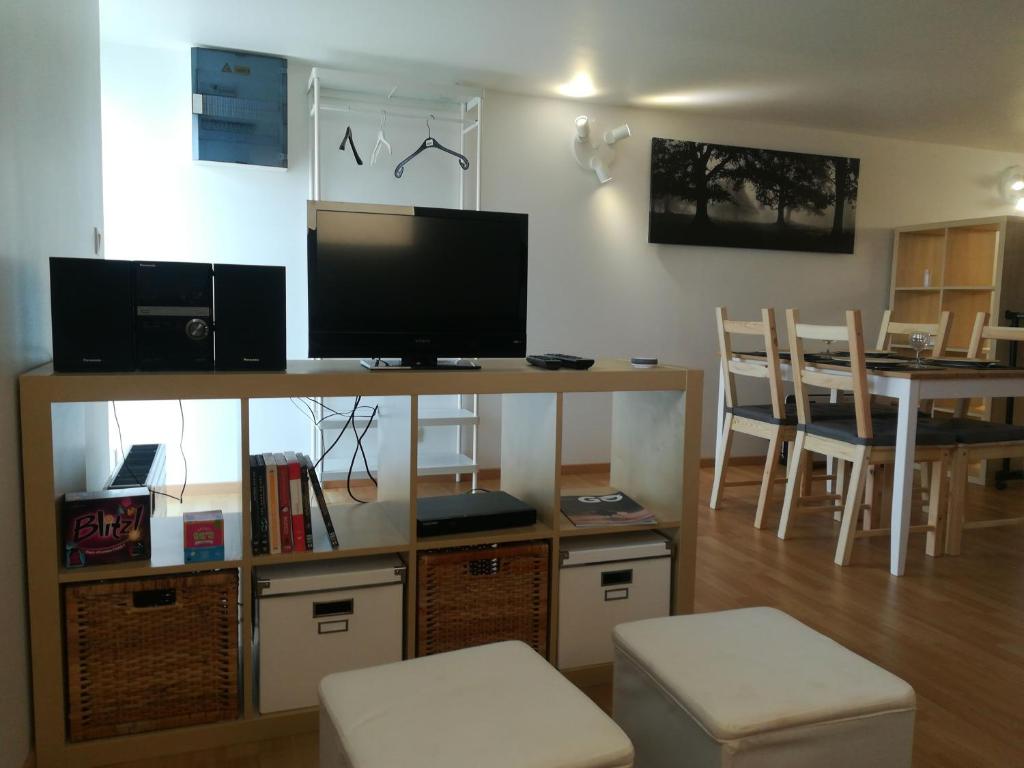 ein Wohnzimmer mit einem TV und einem Esszimmer in der Unterkunft Le willou in Malmedy