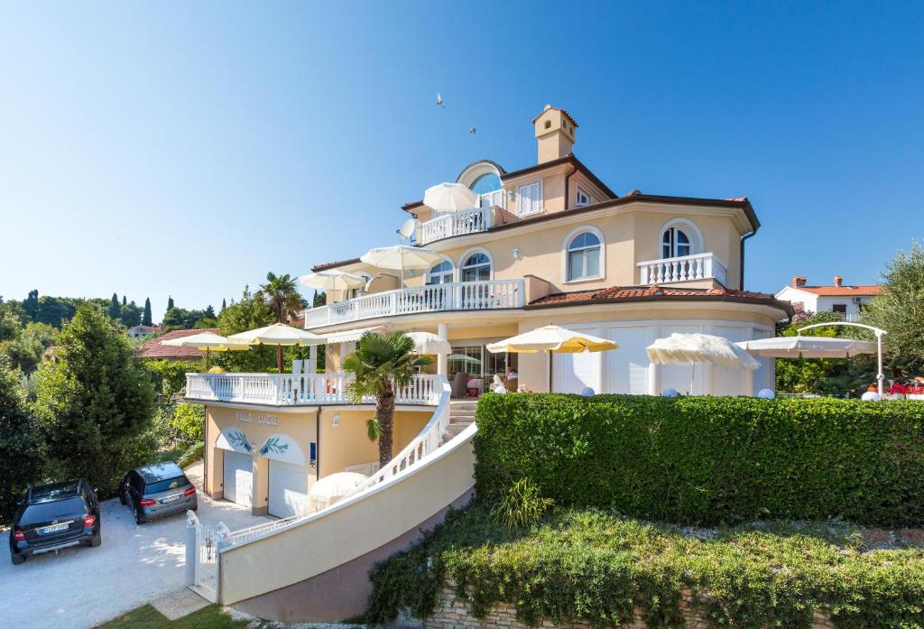 a large house with a car parked in front of it at Apartments Lucie in Premantura