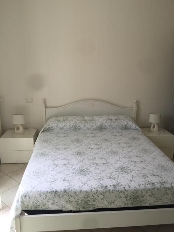 a bedroom with a white bed with two night stands at B&B Gigi’ in Marina di Massa