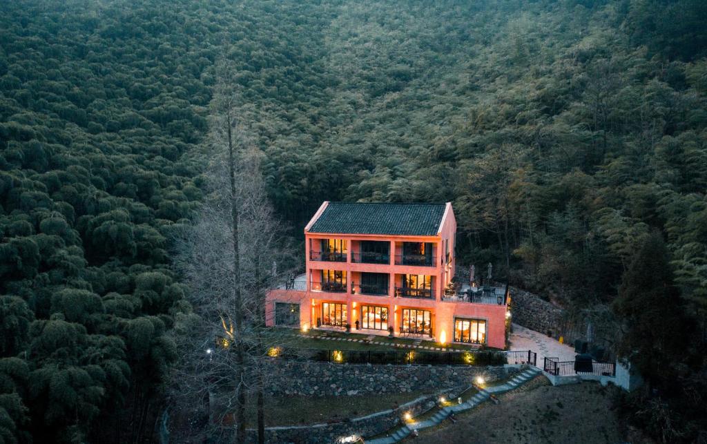 a large house in the middle of a forest at Arcadia Resorts in Deqing