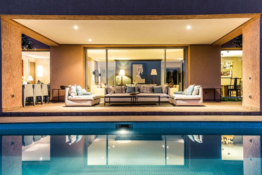 uma casa com piscina e sala de estar em Al Maaden 132 - Luxury front line golf villa with heated pool em Marraquexe