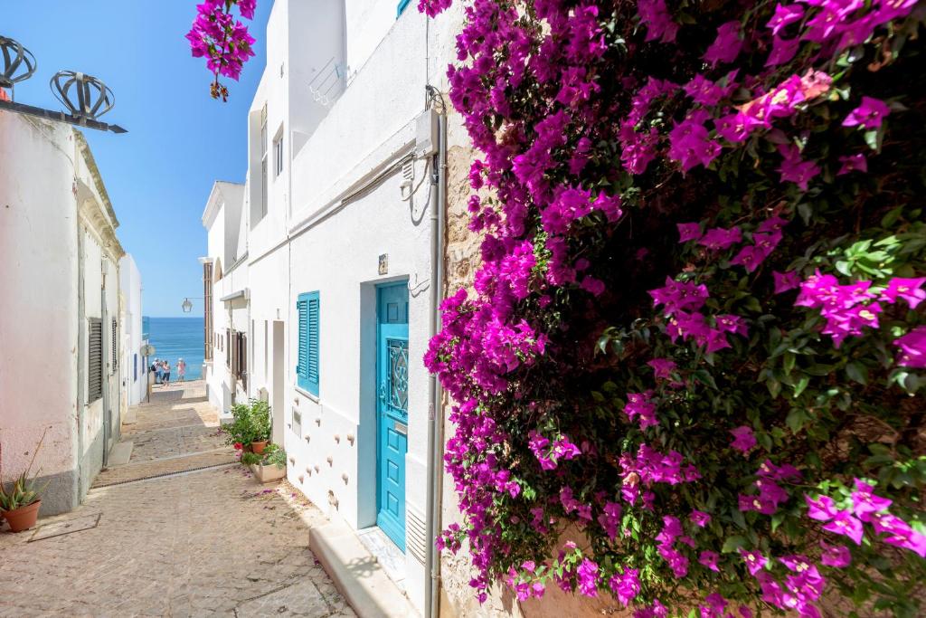 a street in positano with purple flowers on a building at FLH Muralhas da Vila Apartment in Albufeira