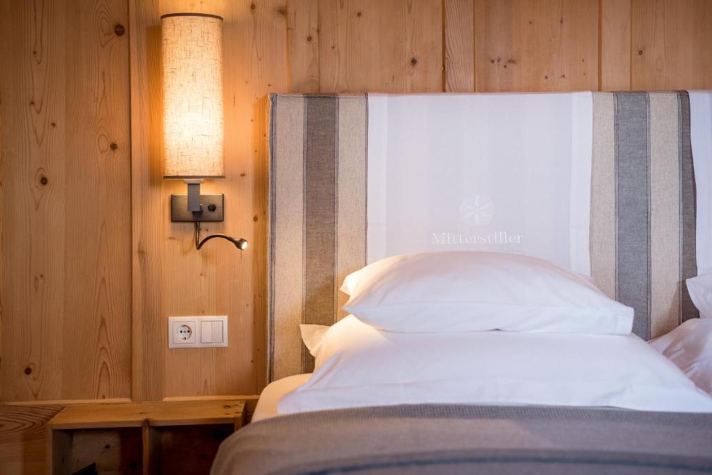 a bedroom with a bed with a light on the wall at Mitterstiller in Auna di Sotto