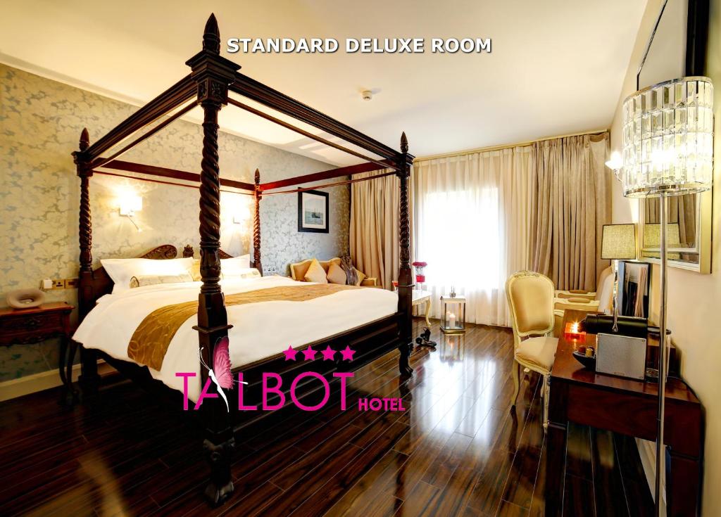 a bedroom with a canopy bed and a desk at The Talbot Hotel in Belmullet