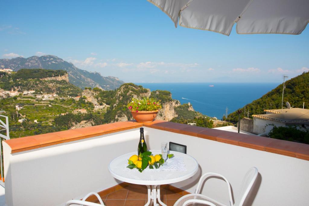 uma mesa e cadeiras numa varanda com vista para o oceano em DAME casa vacanza em Amalfi