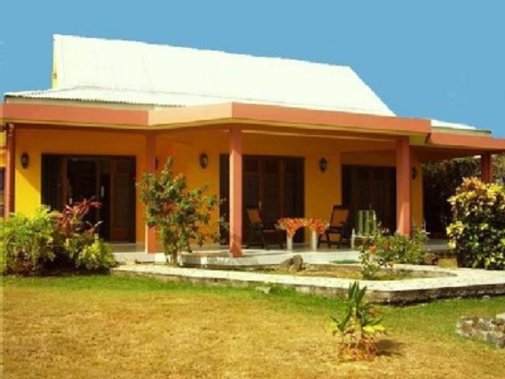 聖安妮的住宿－Villas Créoles，院子内带桌子的小黄色房子