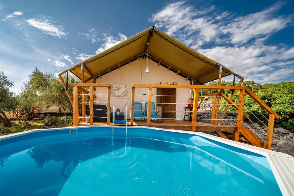 uma casa com uma piscina em frente em Krk glamping village em Krk