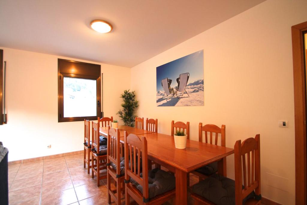 een eetkamer met een houten tafel en stoelen bij Pont de Toneta 6,1 Atico Duplex, Ransol, Zona Grandvalira in Ransol