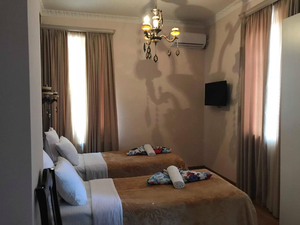 a hotel room with two beds and a chandelier at Apartment Botanikuri 15 in Tbilisi City