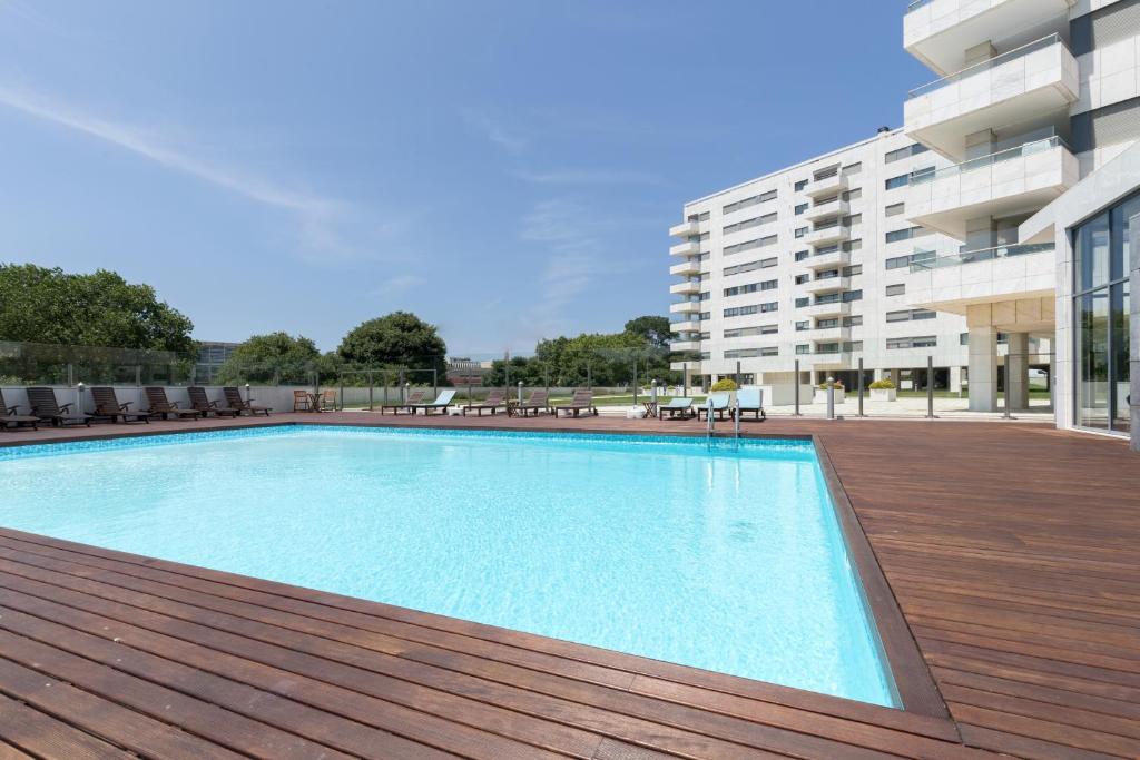 duży basen na tarasie obok budynku w obiekcie Deluxe Condominium with Ocean View w Porto