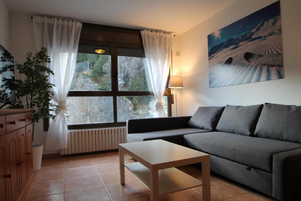 a living room with a couch and a large window at Pont de Toneta 1,3 Ransol, Zona Grandvalira in Ransol