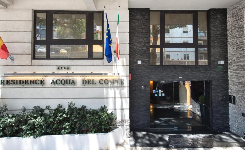 a building with a door and flags in front of it at Residence Acqua del Conte in Messina