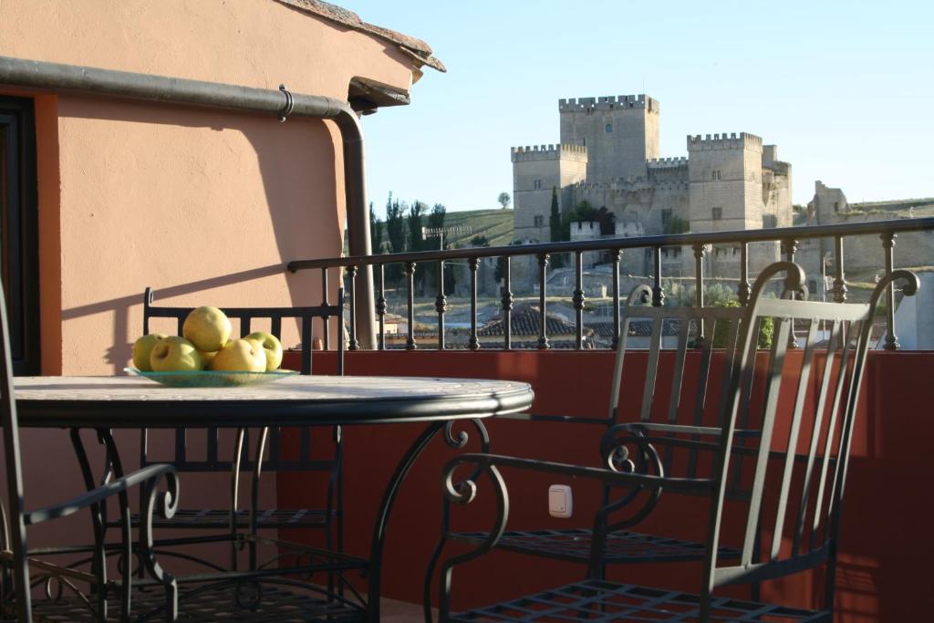 a table and chairs on a balcony with a view of a city at Las Casitas de Papel in Ampudia