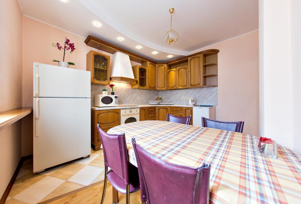 ウファにあるSutkiUfa Рихарда Зорге 70/2.2のキッチン(テーブル、紫色の椅子、冷蔵庫付)
