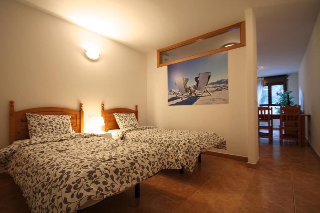 1 dormitorio con 2 camas y una foto en la pared en Pont de Toneta 2,2 Ransol, Zona Grandvalira, en Ransol