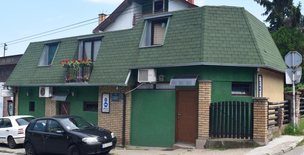 een groen huis met een auto ervoor geparkeerd bij Apartment Jancic in Smederevo