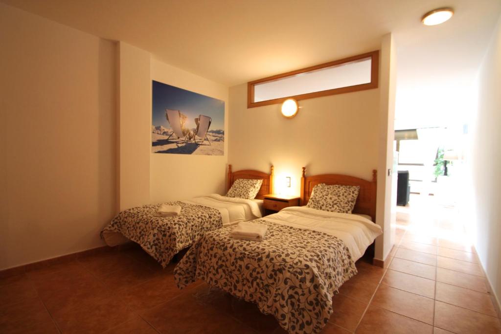 a hotel room with two beds and a window at Pont de Toneta 2,6 Ransol, Zona Grandvalira in Ransol