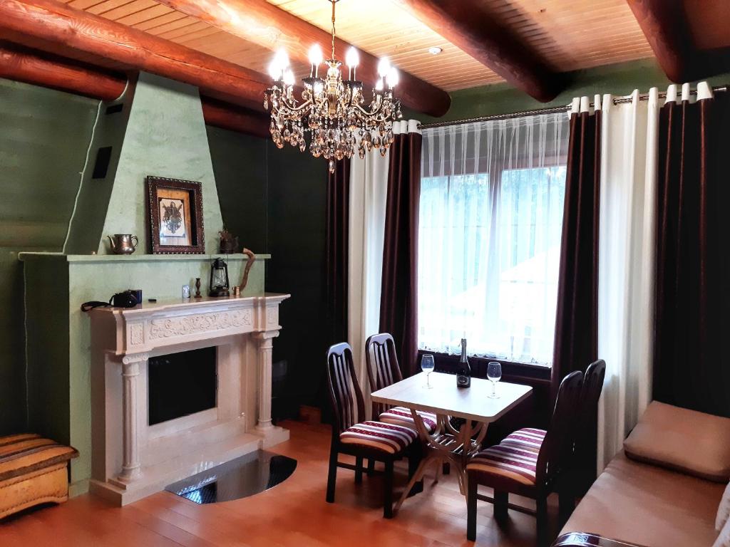 a dining room with a fireplace and a table and chairs at Knyazhyi Dvir in Myslivka