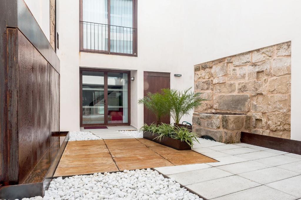 una casa con una pared de piedra y un patio en Can Vent Boutique Hotel, en Alcudia