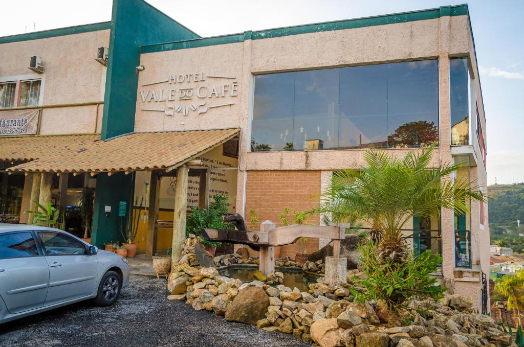 a car parked in front of a building at Hotel Vale do Café in Machado