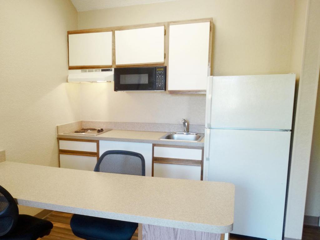 a small kitchen with a refrigerator and a sink at Extended Stay America Select Suites - Orlando - Lake Mary - 1040 Greenwood Blvd in Lake Mary