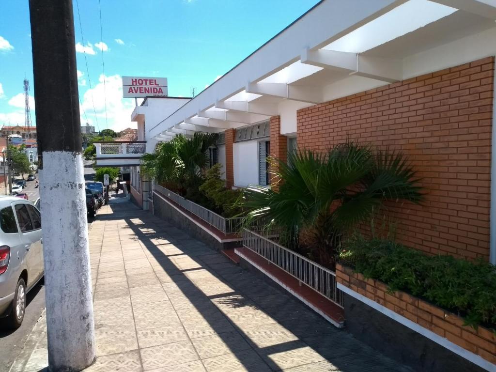 een gebouw met een bord aan de zijkant bij Hotel Avenida in Jacarèzinho