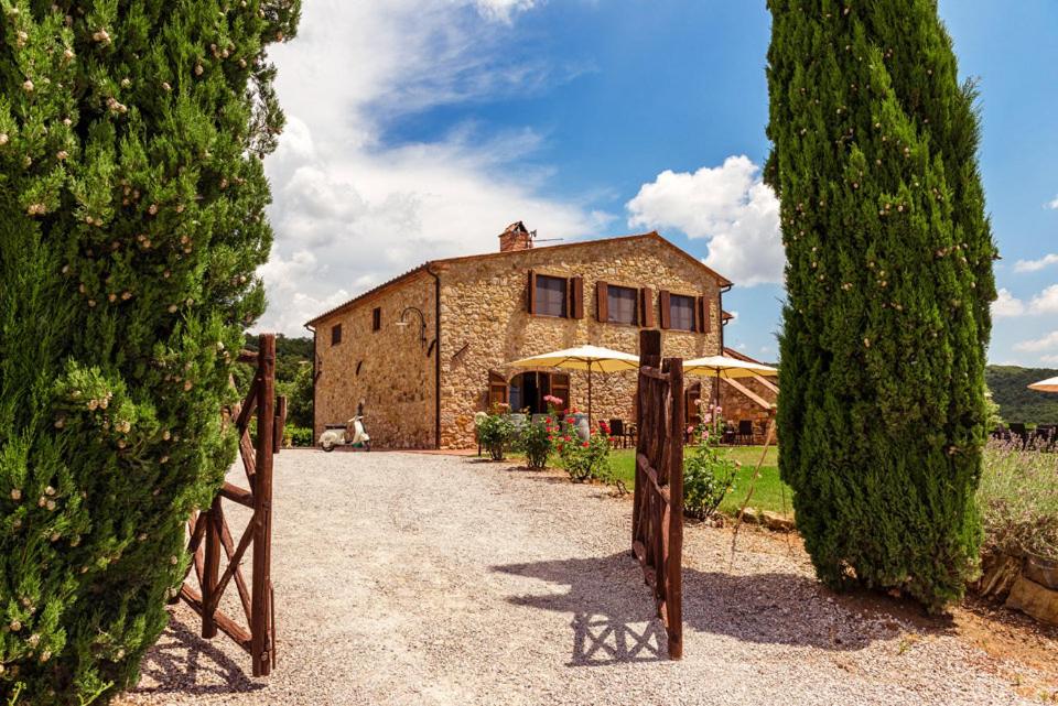 Ribolla的住宿－Agriturismo & Cantina Tenuta Casteani，一座带栅栏和树木的建筑的入口