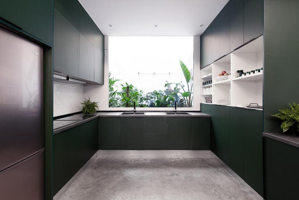 una cocina con armarios verdes y fregadero en 2060 The Newton Hostel, en Madrid