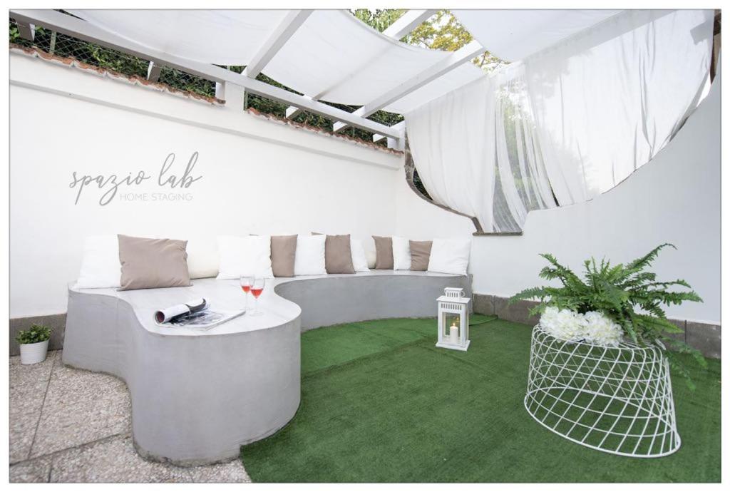 ein weißes Zimmer mit einem Tisch und grünem Gras in der Unterkunft Villa D Apartments in Marino
