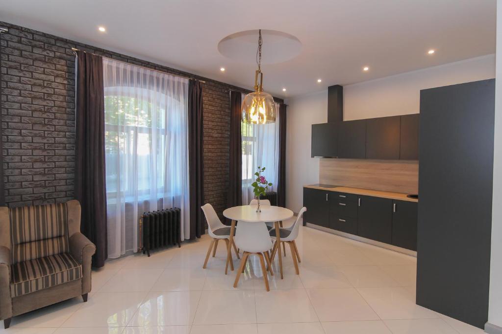 a kitchen and dining room with a table and chairs at Marbella Rezidence in Ventspils