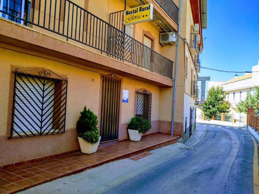 a building with two potted plants on the side of a street at Hostal Rural Gloria in Graena