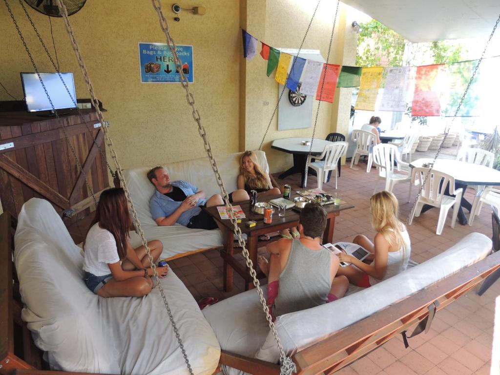 a group of people sitting on a porch swing at Reef Lodge Backpackers in Townsville