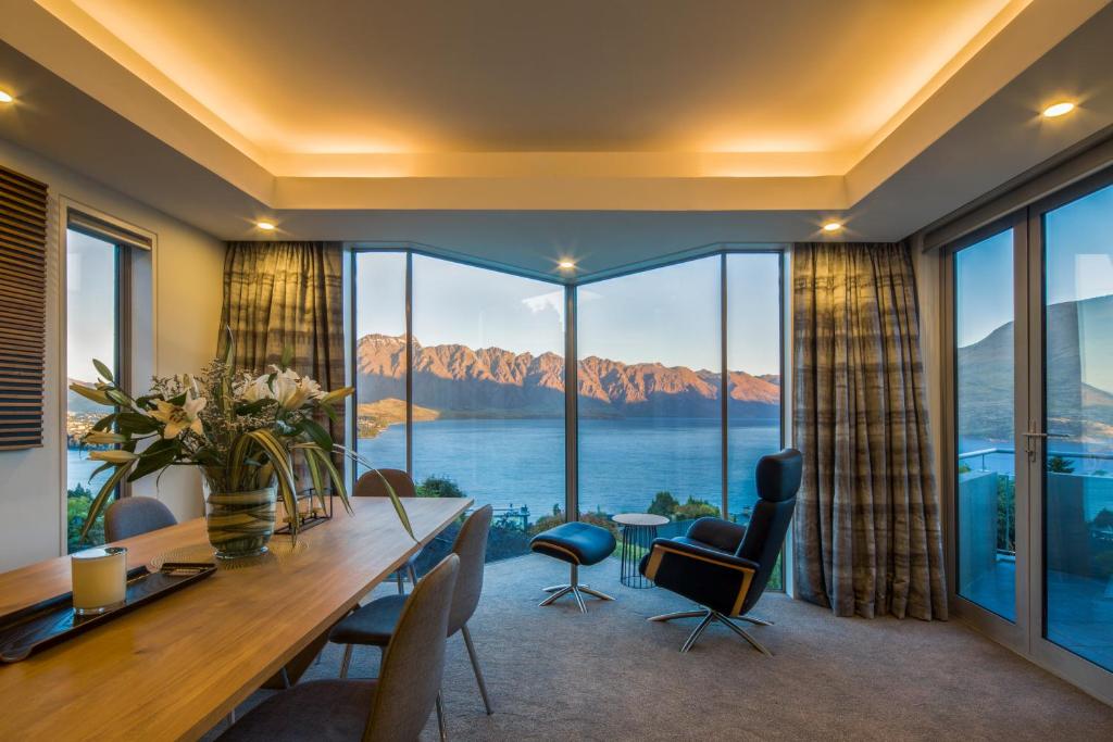 a dining room with a view of the water and mountains at Infinity Collection-Queenstown Luxury House in Queenstown