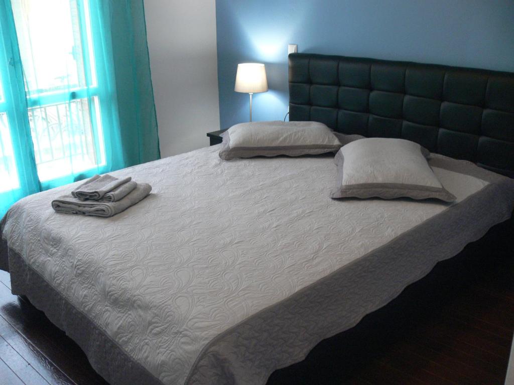 a large bed with two pillows on top of it at Eleni Apartments in Preveza