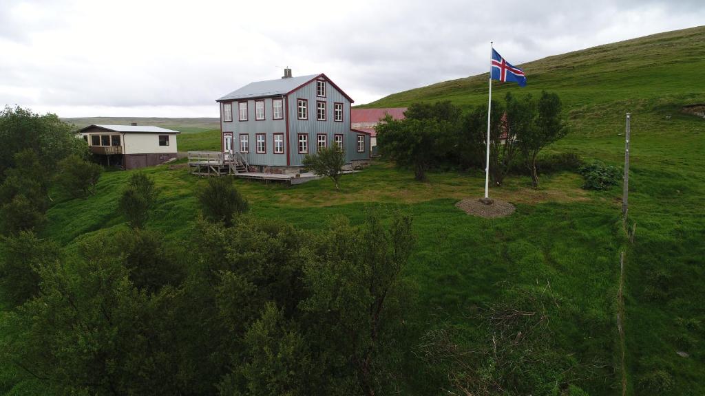 a flag flying in front of a house on a hill at Saudafell Guesthouse in Sauðafell