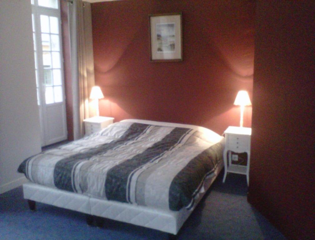 a bedroom with a bed and two night stands with lamps at Les Chambres d'Hôtes de l'Elysée in Pontrieux