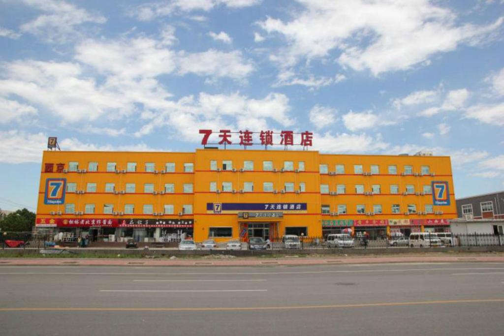 Un grand bâtiment orange avec un panneau en haut dans l'établissement 7Days Inn Beijing Yizhuang Development Zone, à Pékin