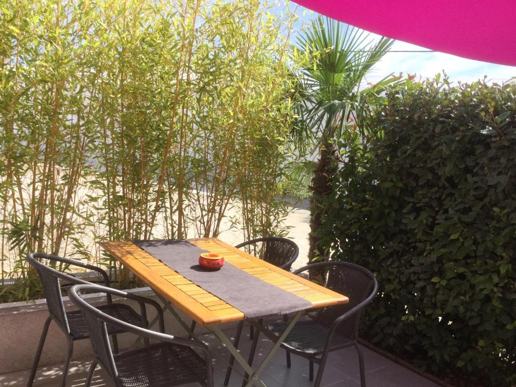 une table et des chaises en bois sur une terrasse dans l'établissement Les Hirondelles, à La Garde