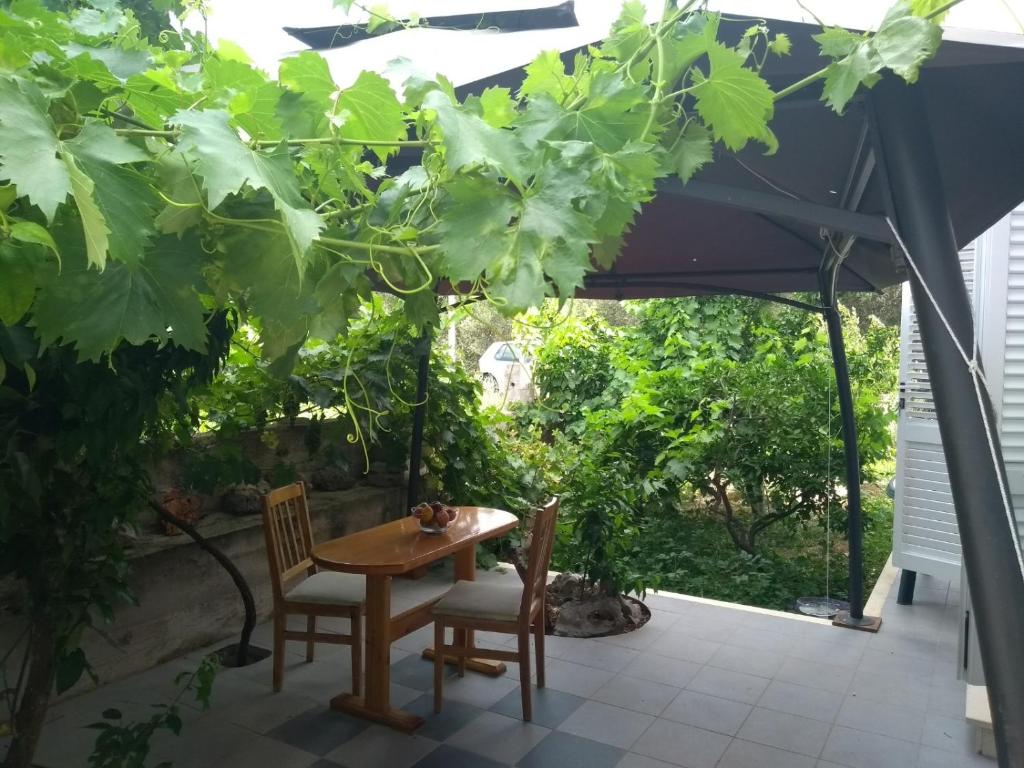 un patio con mesa y sillas bajo un dosel en Apartments Cebalo - Ekonomija, en Korčula