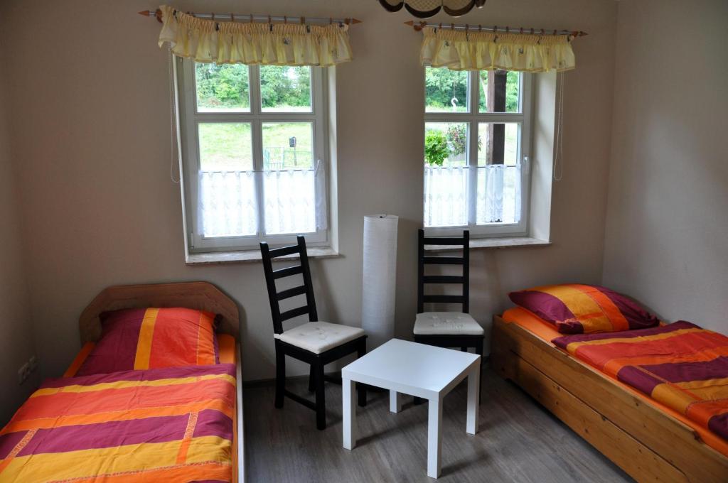 Mellen的住宿－Hof Richert，一间卧室配有两张床、一张桌子和两把椅子